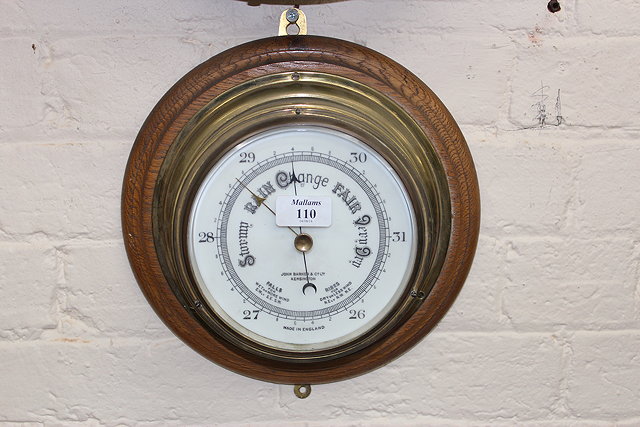 Appraisal: A BRASS SHIPS BULKHEAD ANEROID BAROMETER the six inch ceramic