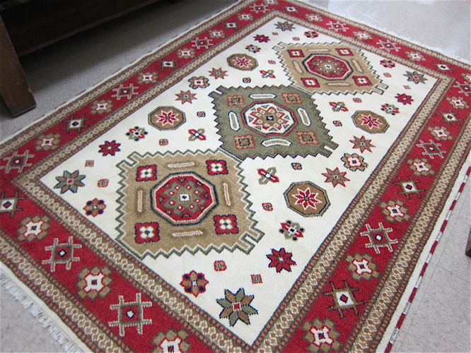 Appraisal: HAND KNOTTED ORIENTAL CARPET Caucasian design featuring a column of