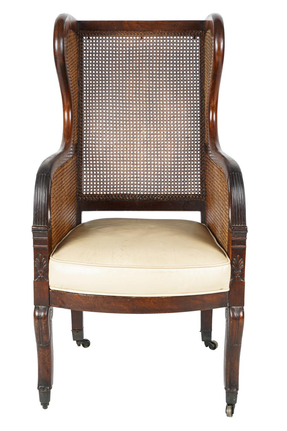 Appraisal: FRENCH EMPIRE STYLE CARVED WALNUT CANE WING CHAIR th century