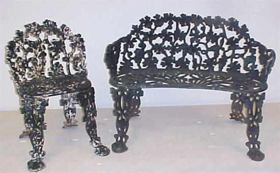 Appraisal: Cast iron garden settee with elaborate pierced grapevine motif backrest