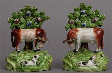 Appraisal: PAIR OF WOODS-TYPE POTTERY COW FIGURES Each modeled with lowered