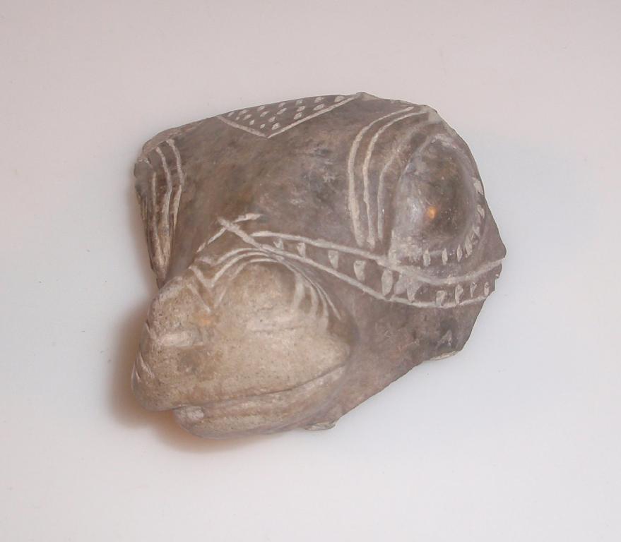 Appraisal: A fragment of a glazed light grey pottery bull's head