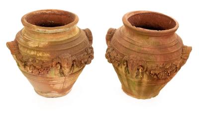 Appraisal: A pair of terracotta finish garden urns with rams mask