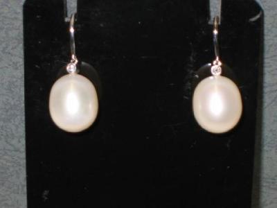 Appraisal: A PAIR OF PEARL EARRINGS slightly oval form mounted with