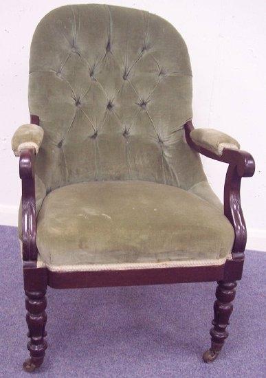 Appraisal: A Victorian button back chair with padded arms on turned