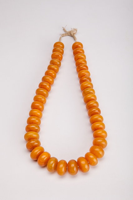 Appraisal: AN AMBER BEAD NECKLACE light egg yolk coloured cushion shaped