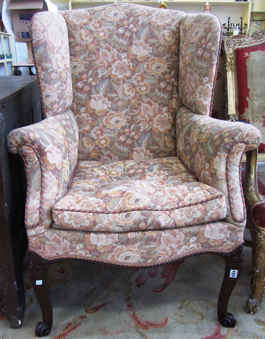 Appraisal: An th century style wingback armchair on carved mahogany cabriole