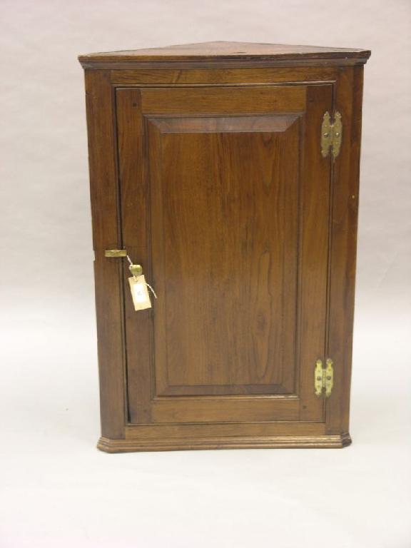 Appraisal: A small George III oak corner cupboard three shelves enclosed