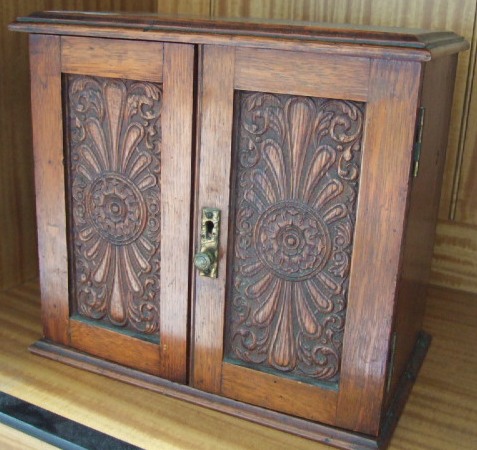 Appraisal: A early th century oak smokers cabinet with carved doors