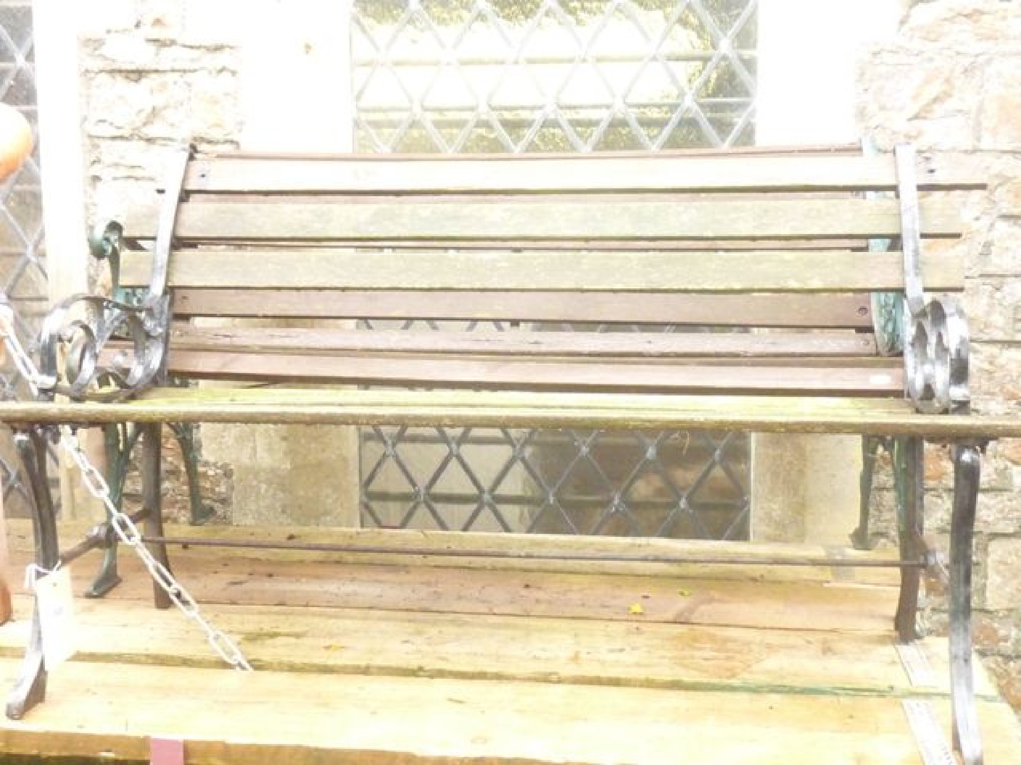 Appraisal: A two seat garden bench with weathered timber slatted seat