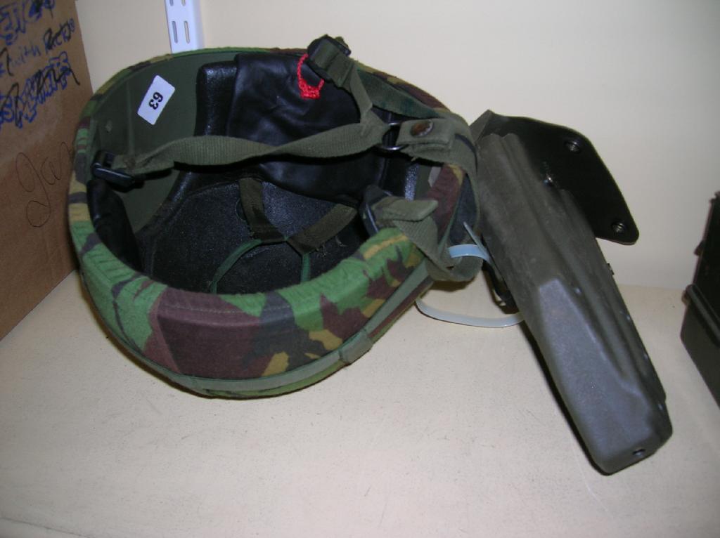 Appraisal: A British Mark combat helmet dated together with its camouflaged