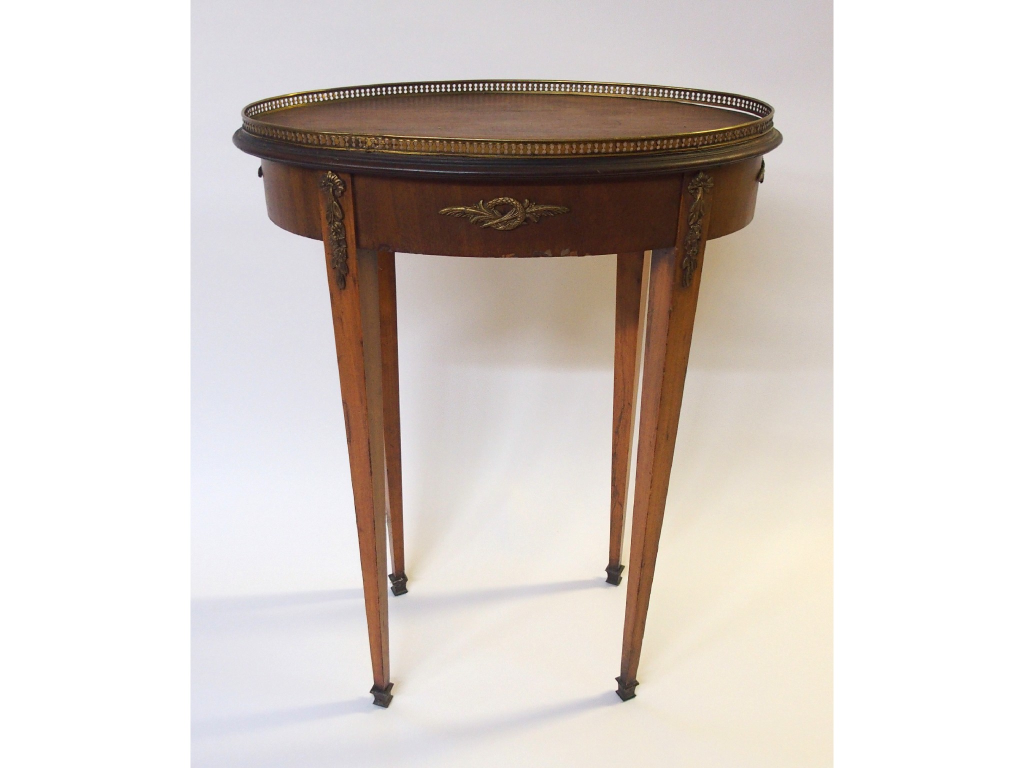 Appraisal: A French mahogany and brass mounted oval occasional tablewith pierced