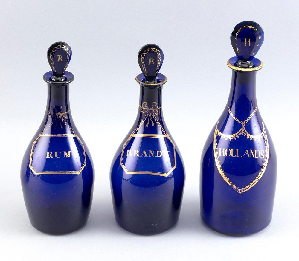 Appraisal: THREE GILT-DECORATED COBALT BLUE GLASS LIQUOR BOTTLES FIRST HALF OF