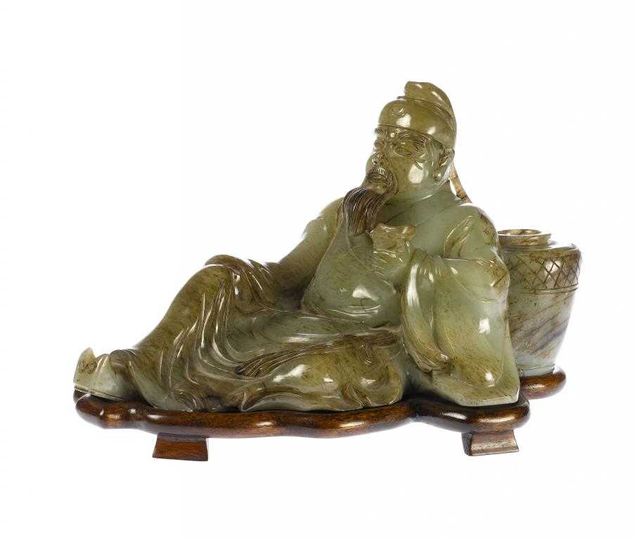 Appraisal: A CHINESE JADE CARVING OF AN IMMORTAL reclining with a