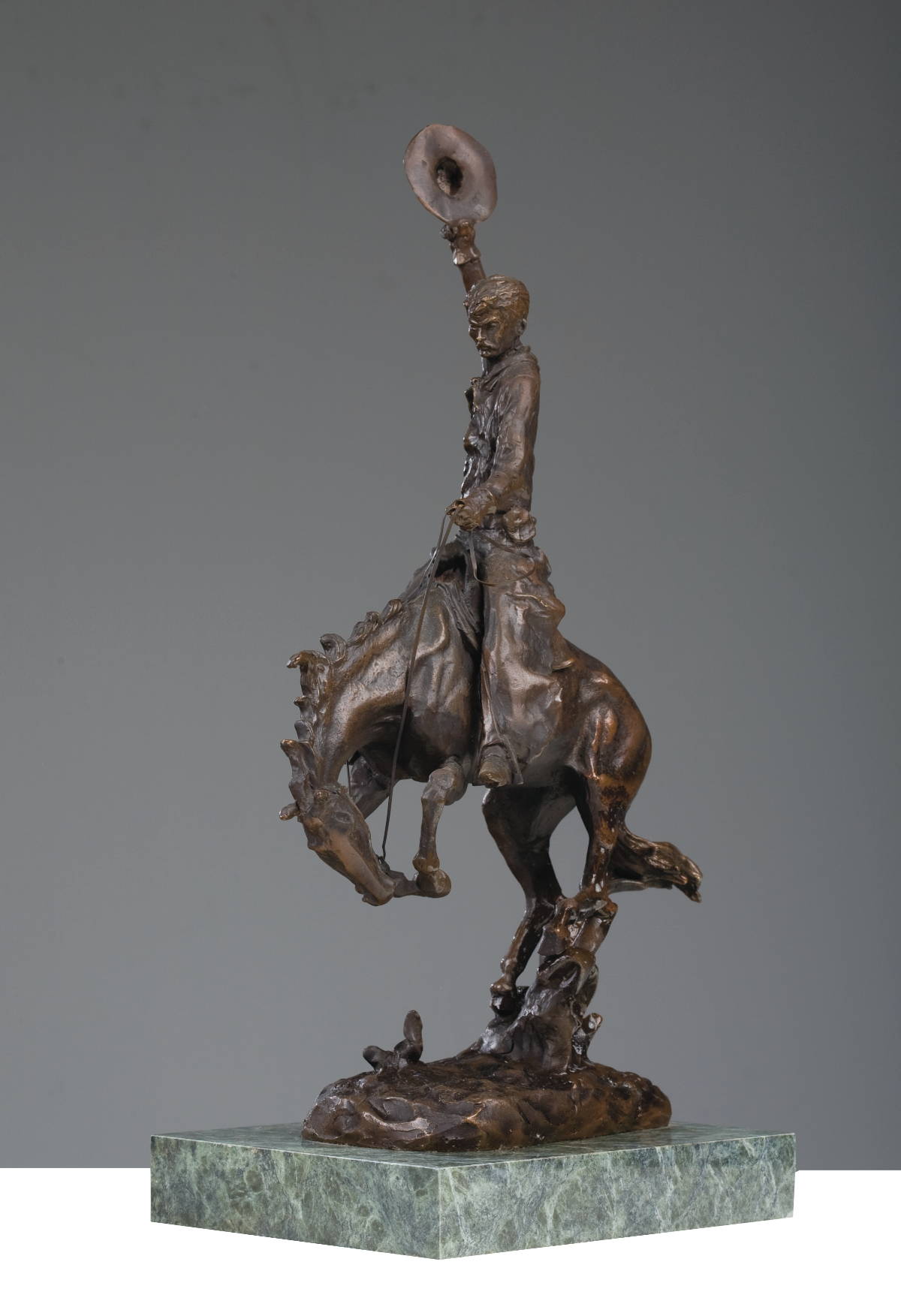 Appraisal: BRONZE FIGURE OF A COWBOY RIDING A BUCKING BRONCO AFTER