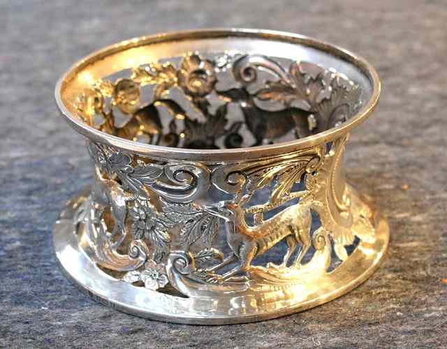 Appraisal: A SILVER DISH RING with waisted sides pierced with animal