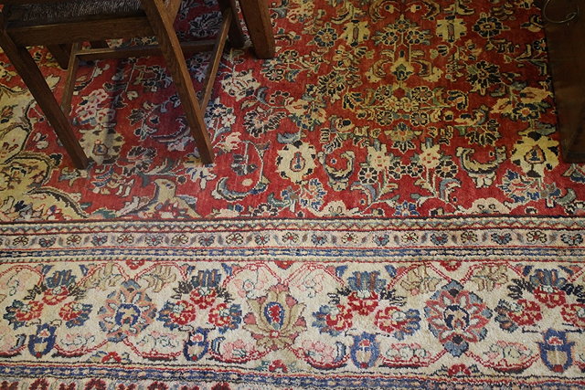 Appraisal: AN AKHAVAN LARGE WOOL RED GROUND CARPET with small central