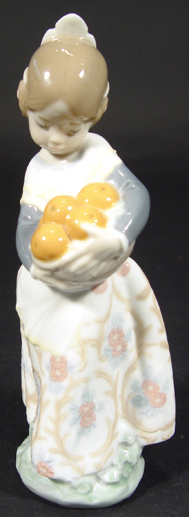 Appraisal: Lladro porcelain figurine clutching oranges with hand painted decoration printed