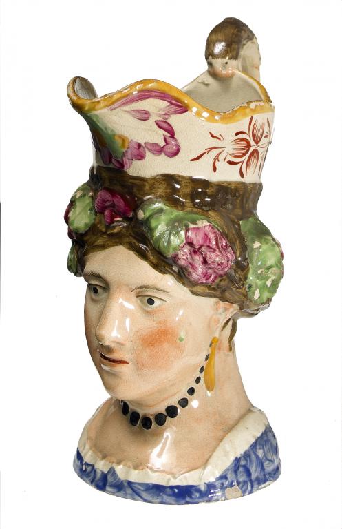 Appraisal: A PEARLWARE JUG modelled as the head of a young