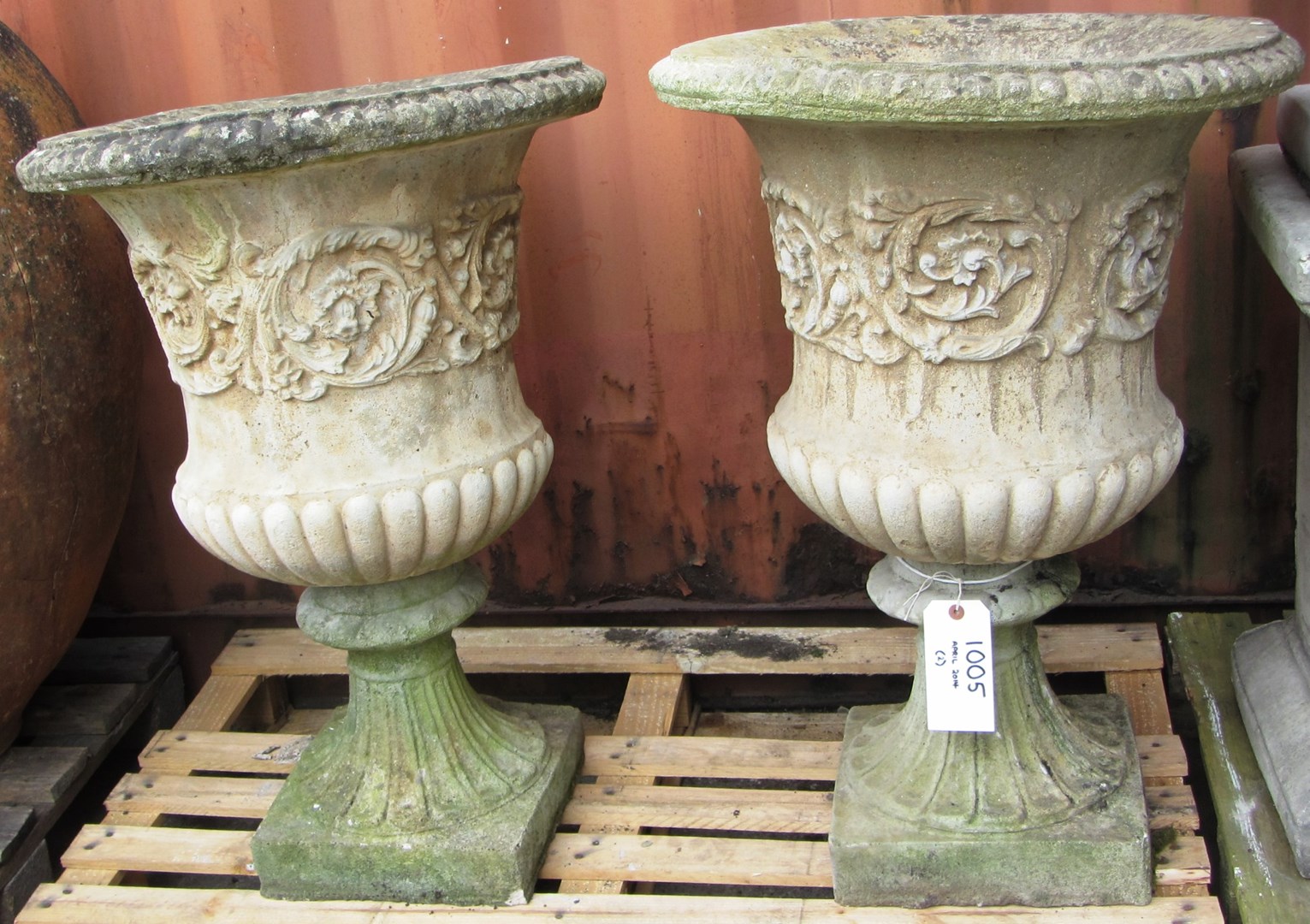 Appraisal: A pair of reconstituted stone campana shaped urns on socles