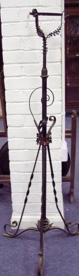 Appraisal: An adjustable wrought iron oil lamp stand of scrolling form