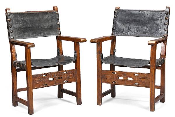 Appraisal: A pair of Spanish Baroque walnut and leather armchairs Each