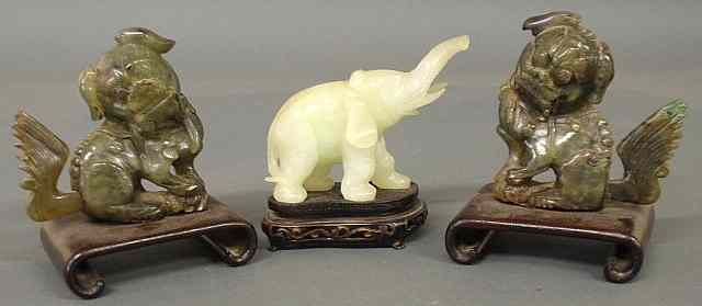 Appraisal: Two spinach jade foo dogs set on scrolled wooden bases