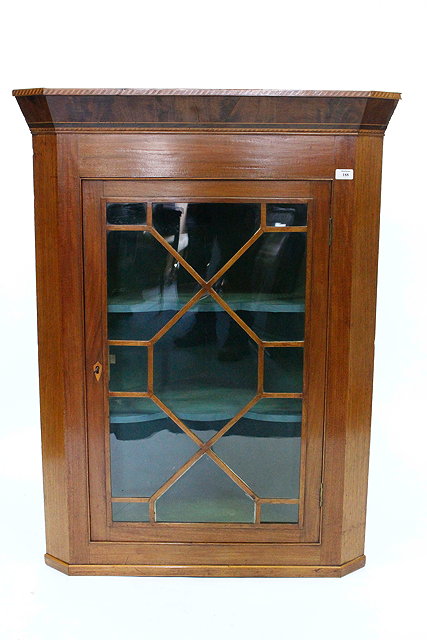 Appraisal: A MAHOGANY HANGING CORNER CUPBOARD with enclosed green painted shelves