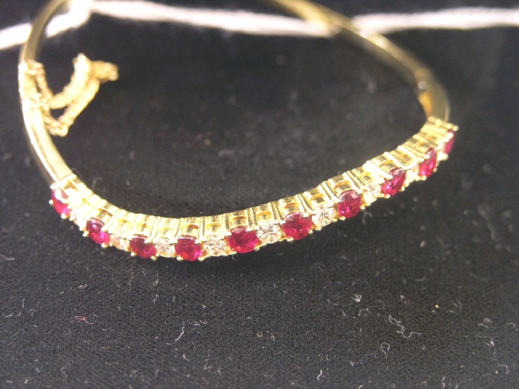 Appraisal: An ct gold diamond and ruby bangle twisted design claw