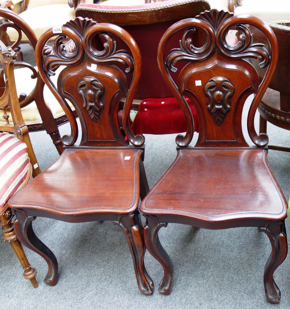 Appraisal: A pair of Victorian mahogany hall chairs with pierced and