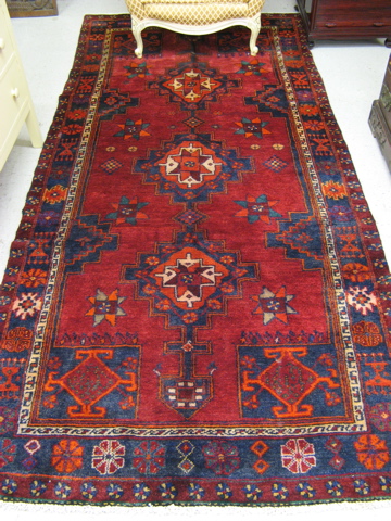 Appraisal: PERSIAN TRIBAL CARPET geometric design on red ground with blue