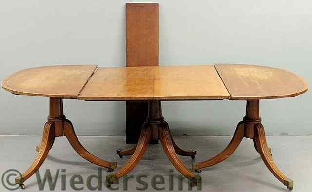 Appraisal: Inlaid mahogany dining table with a triple pedestal base reeded