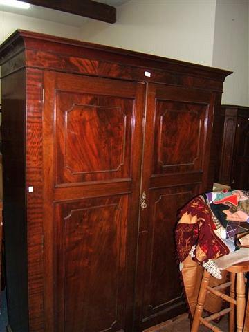 Appraisal: A mahogany wardrobe with twin panelled doors standing on bracket