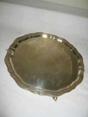 Appraisal: A SALVER with moulded edged rim raised on scroll feet