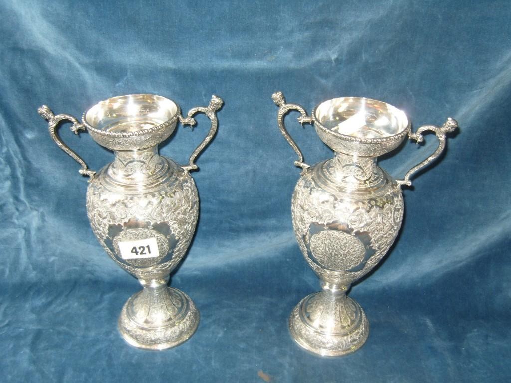 Appraisal: A pair of middle eastern white metal vases on stands