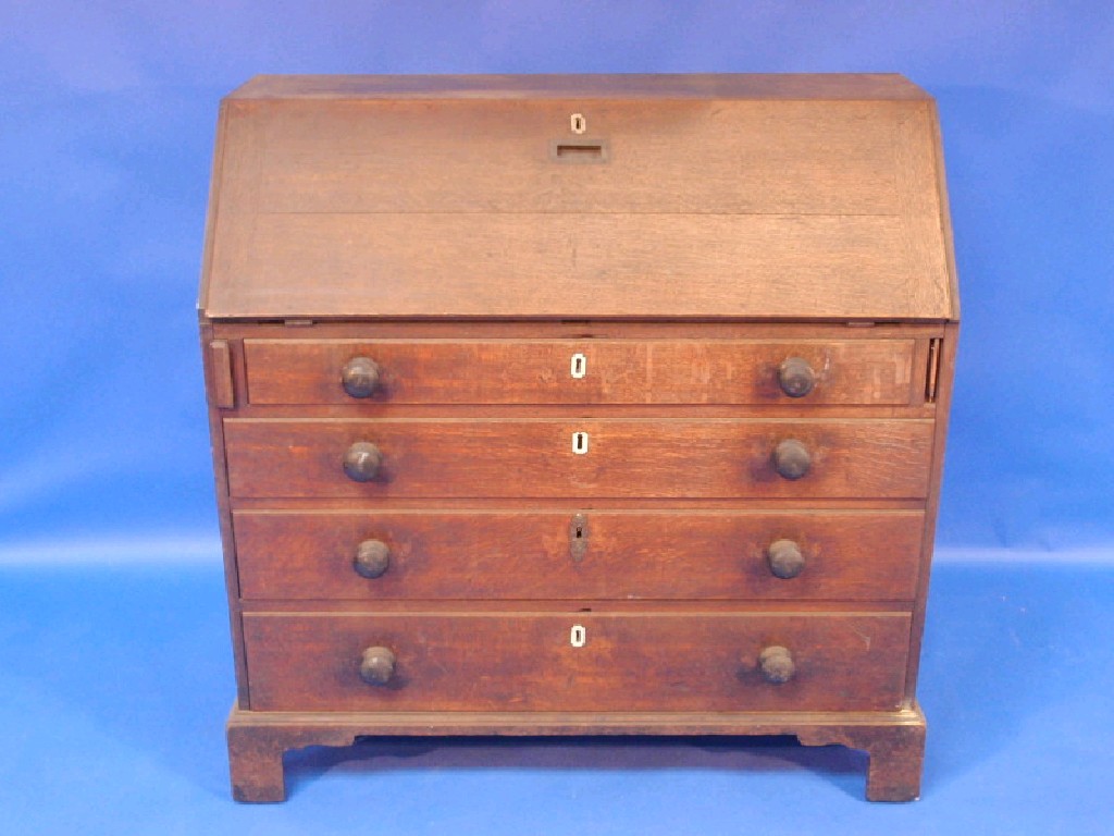 Appraisal: A Georgian oak bureau the fitted interior with mahogany veneer