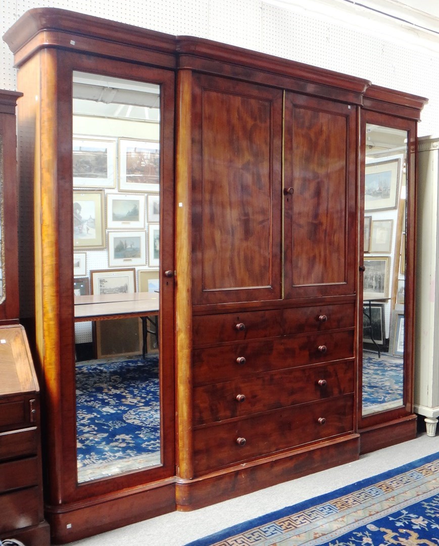 Appraisal: A Victorian mahogany breakfront triple wardrobe the central linen press