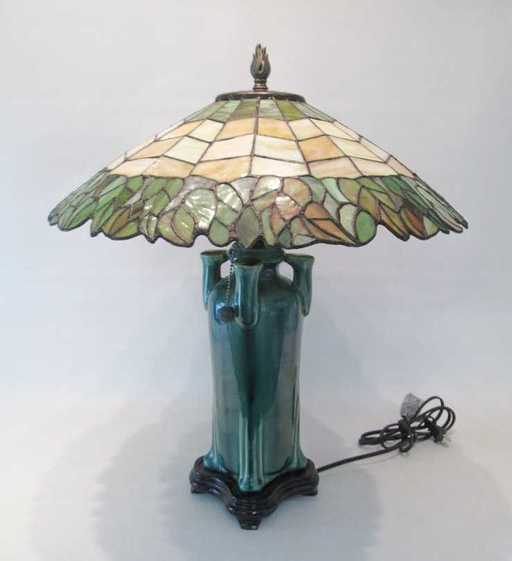 Appraisal: STAINED GLASS AND ART POTTERY TABLE LAMP featuring a D