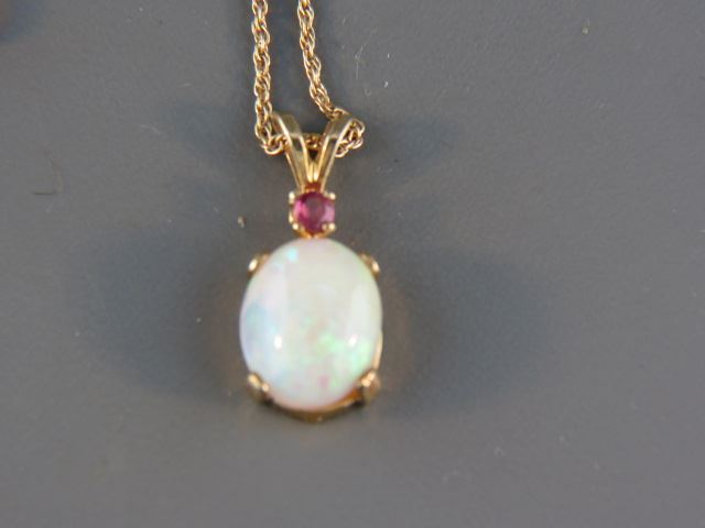 Appraisal: Opal and Ruby Pendant fiery oval cabochon carat gem with