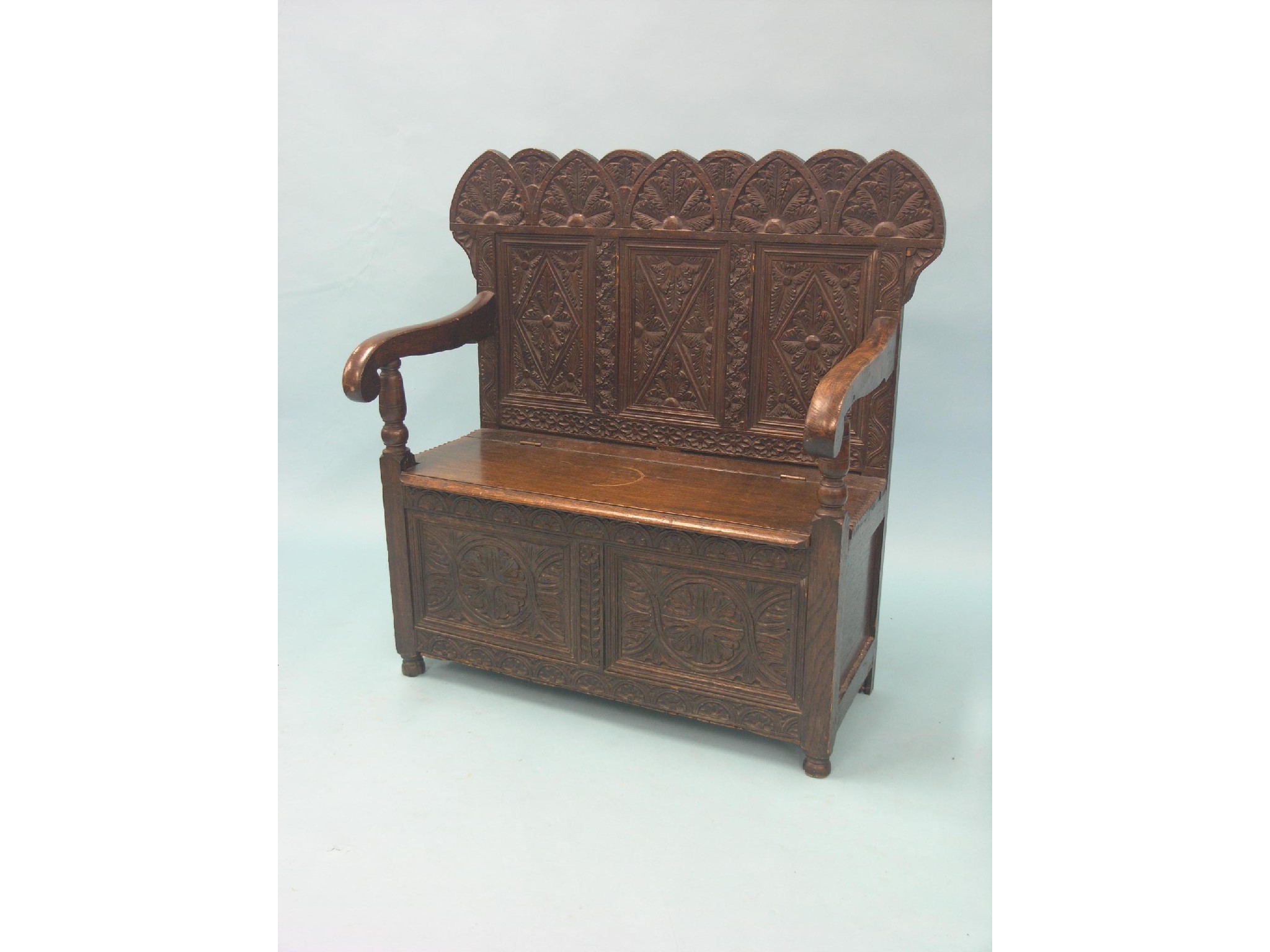 Appraisal: A Victorian dark oak settle twin-seat with carved foliage and