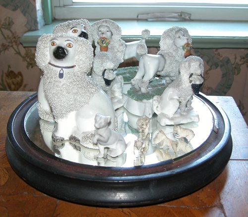 Appraisal: Title Set of Porcelain Poodle Figurines with Glass Dome Medium