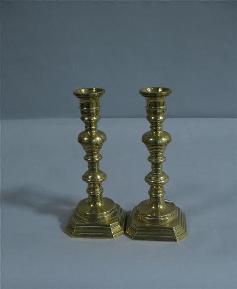 Appraisal: PAIR OF BRASS CANDLESTICKS Set atop stepped square bases with