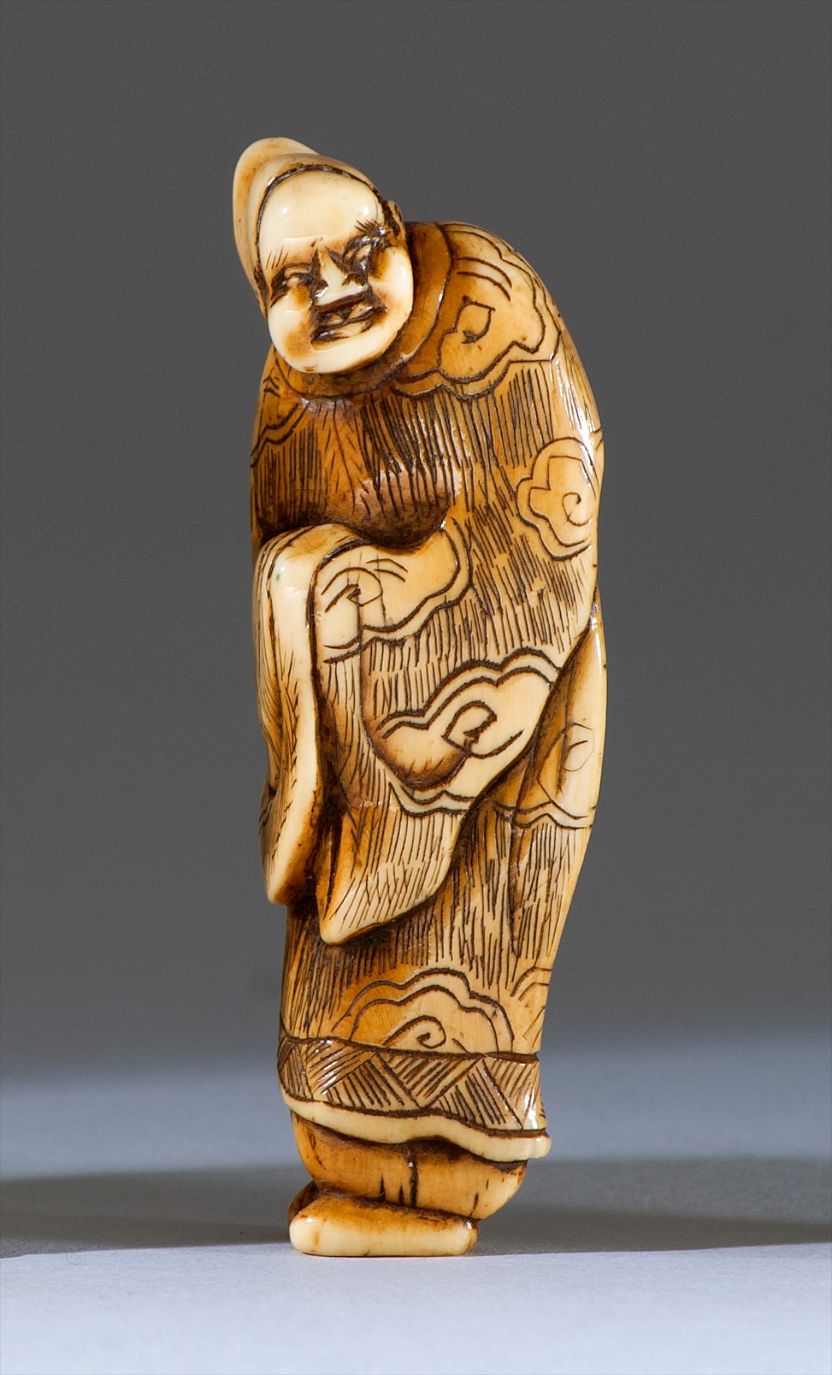 Appraisal: IVORY NETSUKE th CenturyIn the form of a standing Chinese