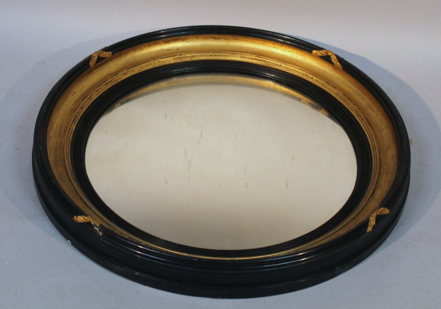 Appraisal: A thC gilt wood and ebonised portal mirror the circular