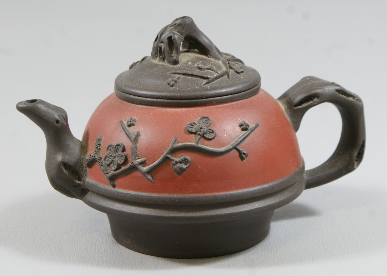 Appraisal: Black and red Chinese terracotta teapot raised prunus flower design