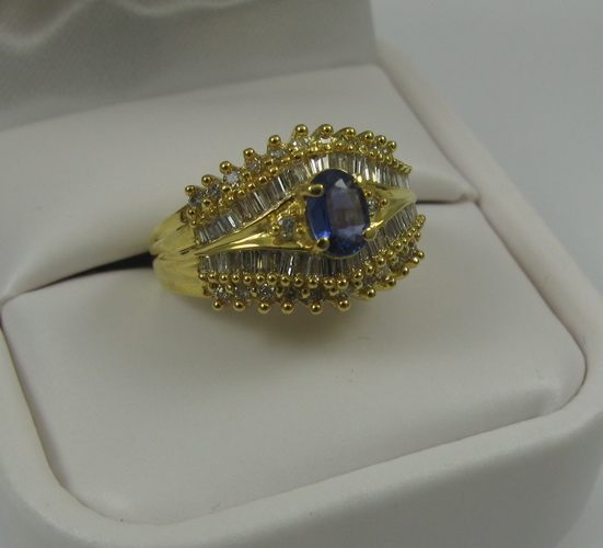 Appraisal: SAPPHIRE DIAMOND AND K GOLD RING centering an oval-cut blue