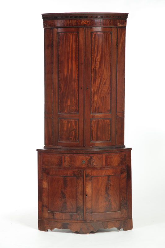 Appraisal: GEORGIAN BARREL FRONT CORNER CUPBOARD England early th century flame