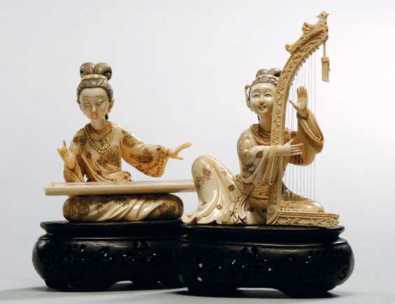 Appraisal: PAIR CARVED IVORY MUSICIANS Pair of finely carved fossil mammoth