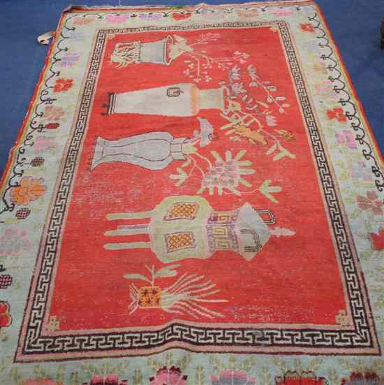 Appraisal: An East Turkestan Khotan vase design red ground rug within