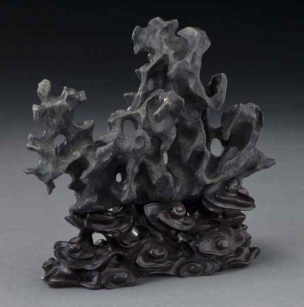 Appraisal: Chinese Qing scholar's rock raised on a finely carved rosewood